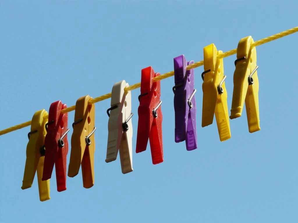 Hanger clips holding freshly dry-cleaned clothes being delivered to a customer's door.